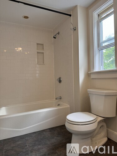 A white toilet sits next to a bathtub in a bathroom.