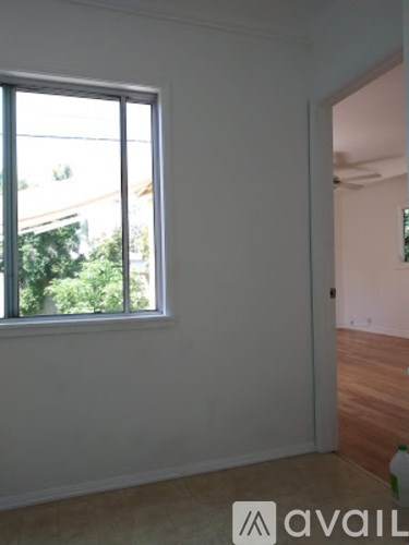 A room with a large window and a wooden floor.