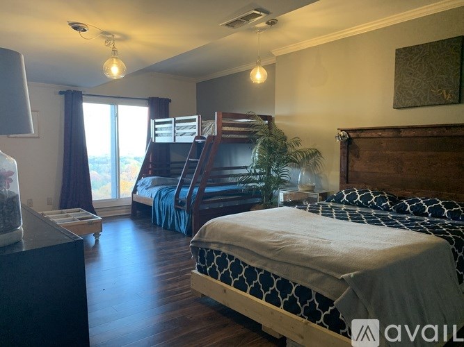 A bedroom with a bed, dresser, and window.