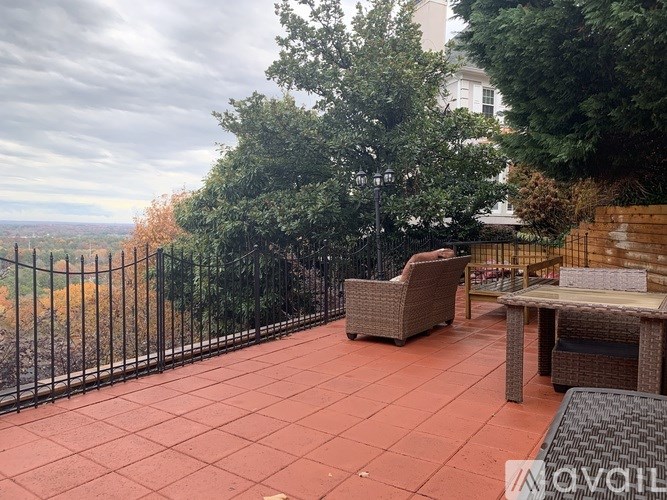 A patio with a table and chairs overlooking a cityscape.