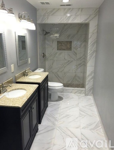 A bathroom with marble floors and a marble shower.