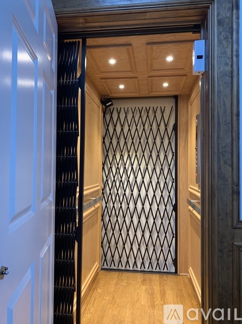 A hallway with a white door and a black gate.