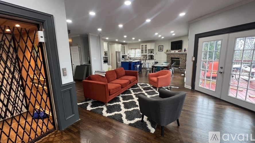 A living room with a red couch and a black chair.