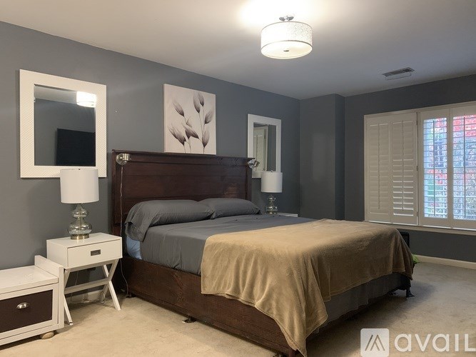 A bedroom with a bed, nightstand, and a lamp.
