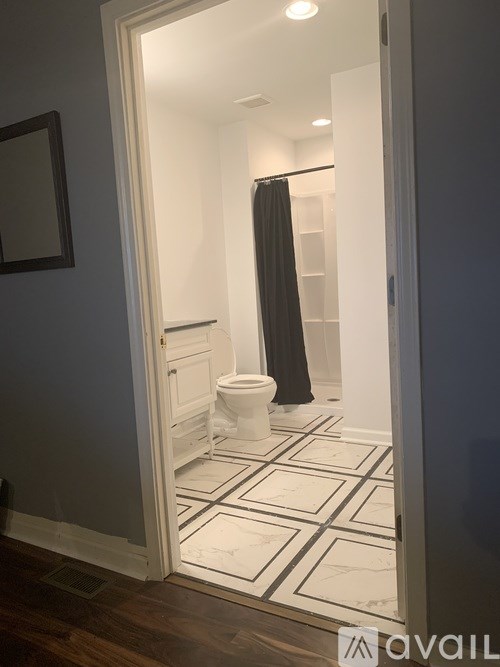 A bathroom with a toilet, sink, and shower.