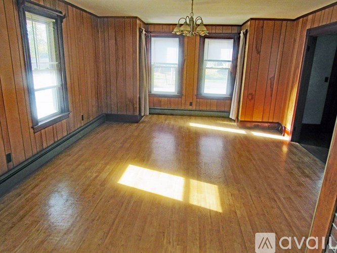 A room with wooden walls and floor and a chandelier hanging from the ceiling.