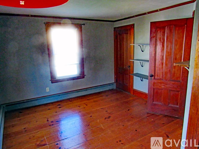 A room with wooden floors and a window.