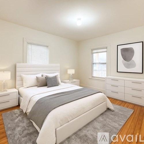 A bedroom with a large bed, nightstands, and a framed artwork on the wall.
