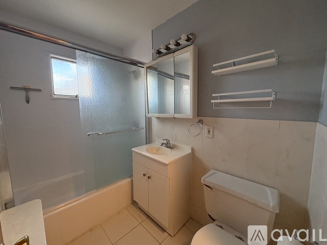 A bathroom with a glass shower door and a white toilet.
