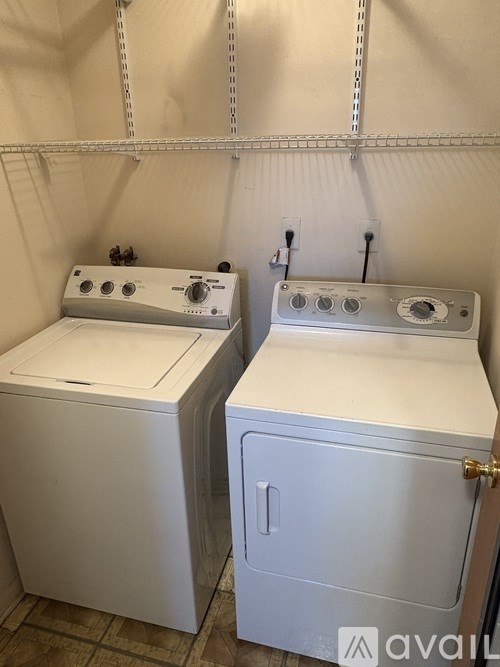Two white front loading washing machines in a laundry room.