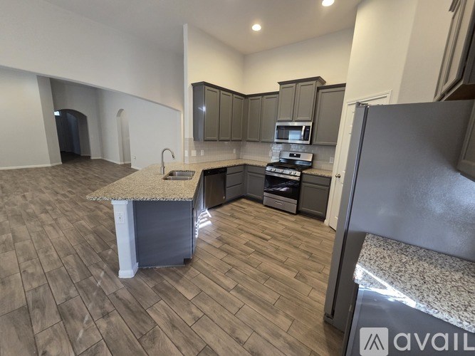 A kitchen with a granite countertop and wooden flooring.