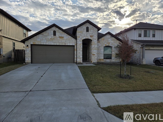 A house with a stone facade and a large driveway.