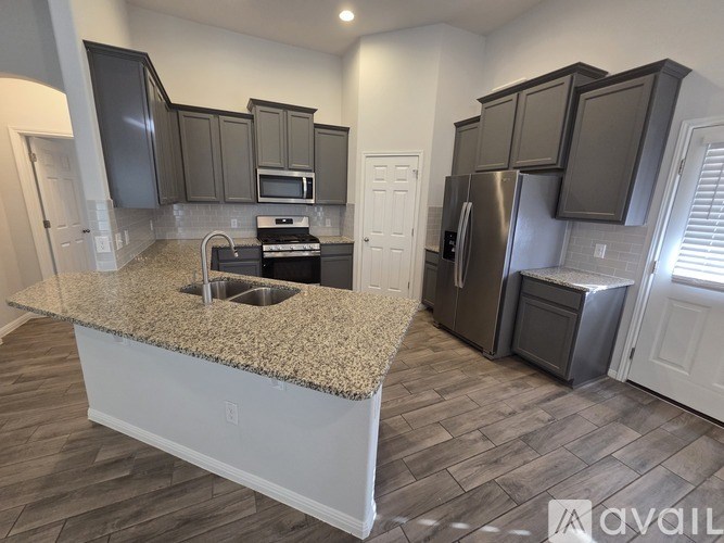 A kitchen with granite countertops and stainless steel appliances.