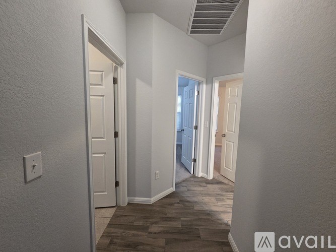 A hallway with a tiled floor and white walls.