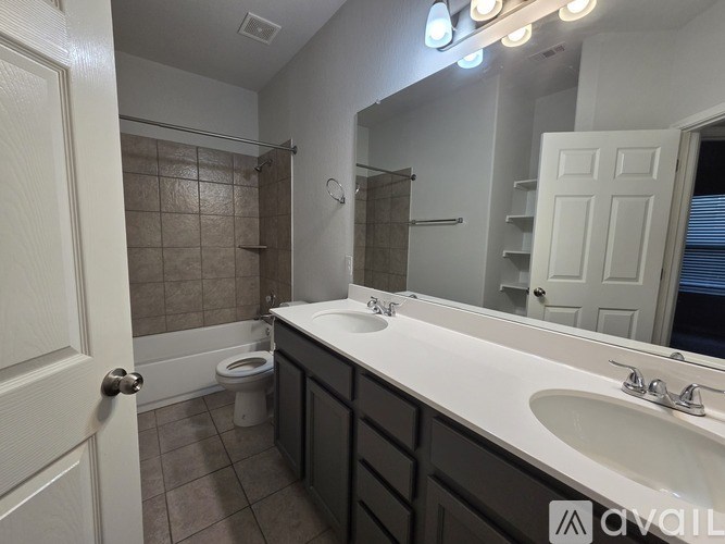 A bathroom with a toilet, sink, and mirror.