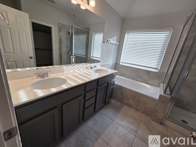 A bathroom with a sink, mirror, and a shower.