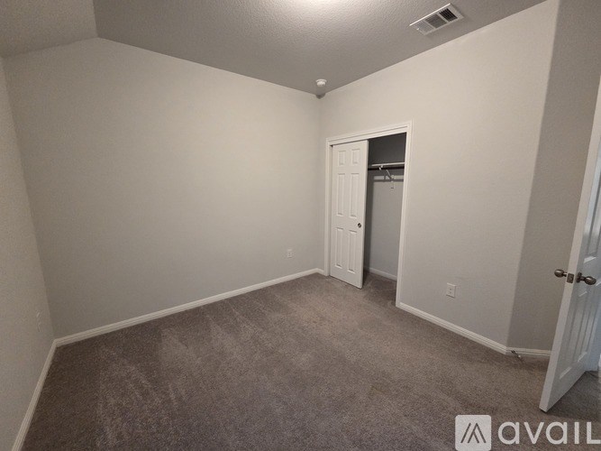 A room with a carpeted floor and a door leading to another room.