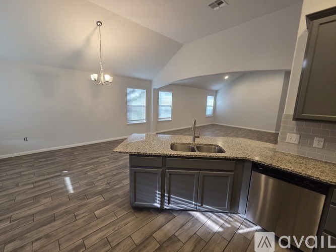 A kitchen with a granite countertop and stainless steel appliances is available for rent.