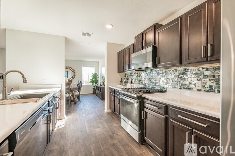 A kitchen with dark wood cabinets and stainless steel appliances.