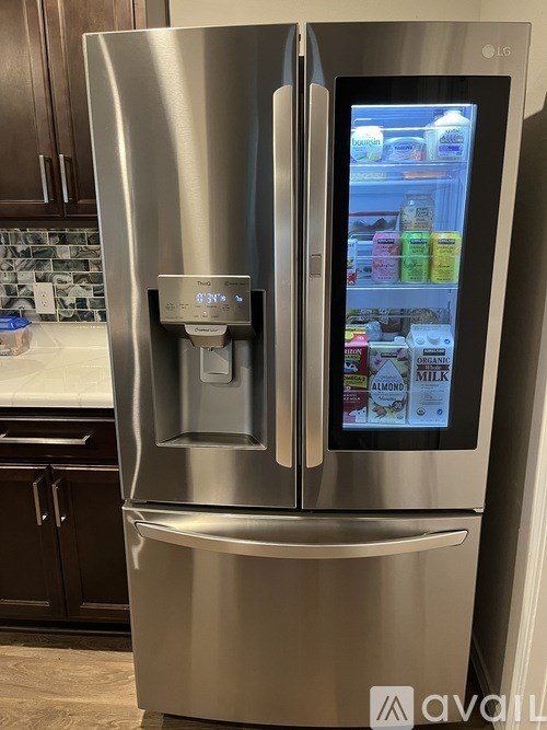 A stainless steel refrigerator with a digital display and a water dispenser.