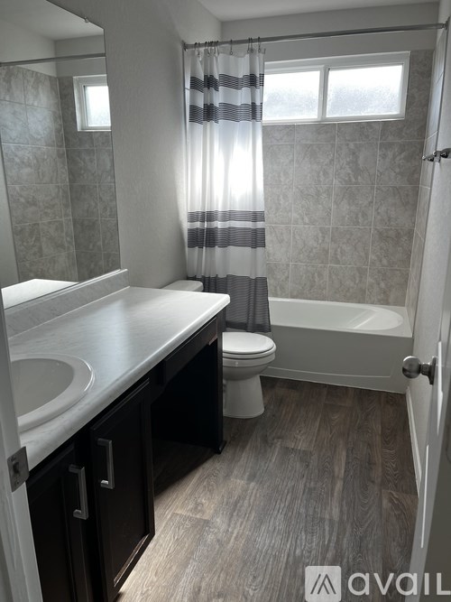 A bathroom with a toilet, sink, and bathtub.