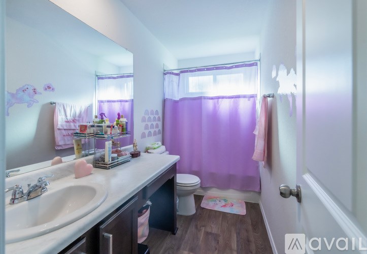 A bathroom with a purple shower curtain and a white sink.