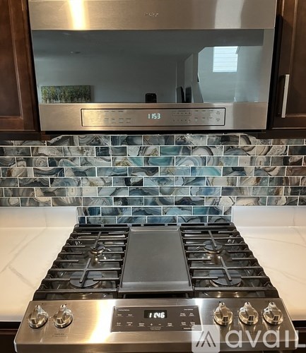 A stainless steel gas stove with a digital display and control panel.