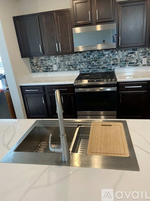 A kitchen with a stove top oven and a sink.