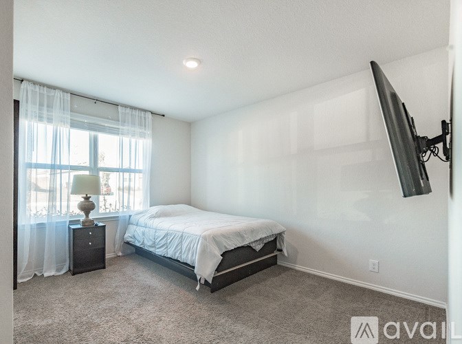 A bedroom with a bed, nightstand, and television.