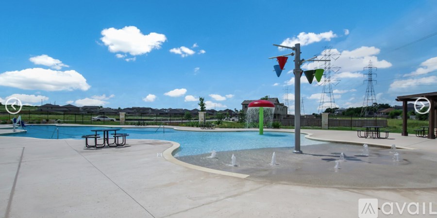 A large outdoor swimming pool with a fountain in the middle.