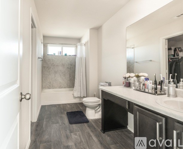 A bathroom with a toilet, sink, and shower.