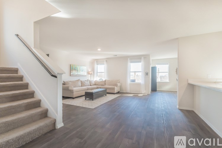 A spacious living room with a staircase leading to the upper floor.