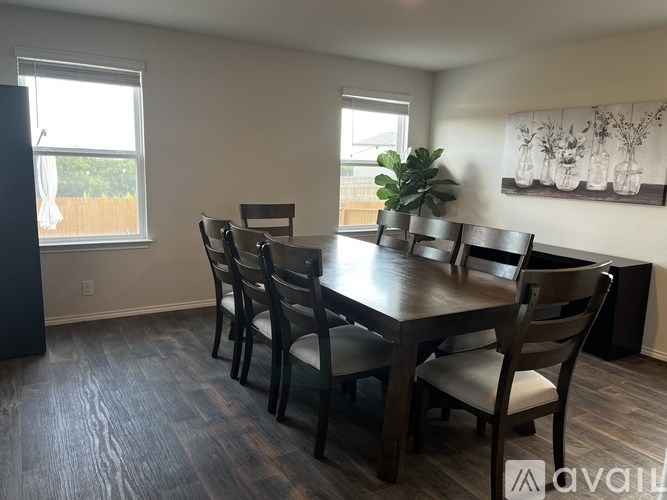 A dining room with a wooden table and chairs.