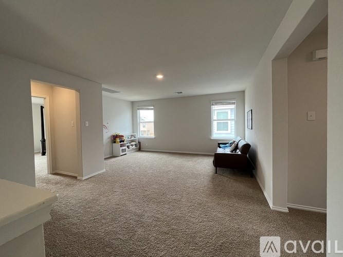 A spacious living room with a carpeted floor and a couch.