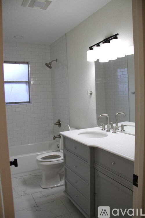 A bathroom with a toilet, sink, and mirror.