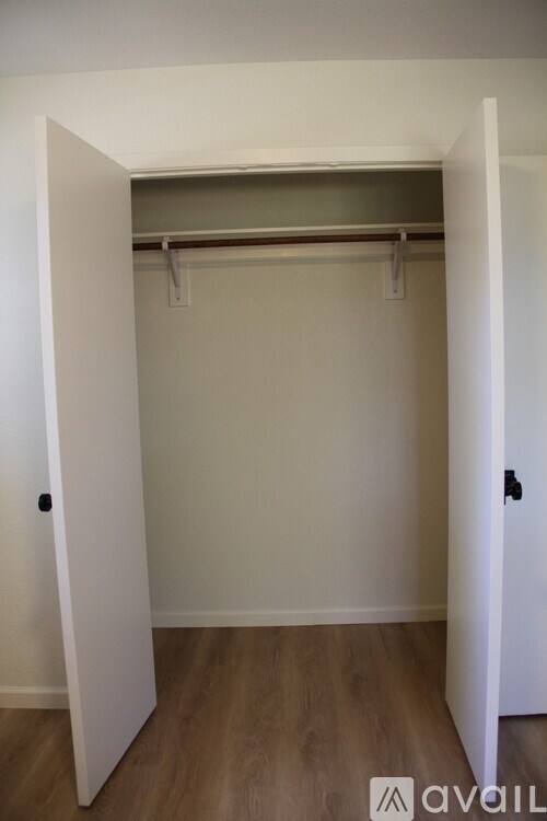 A white door is open to a room with a coat rack.