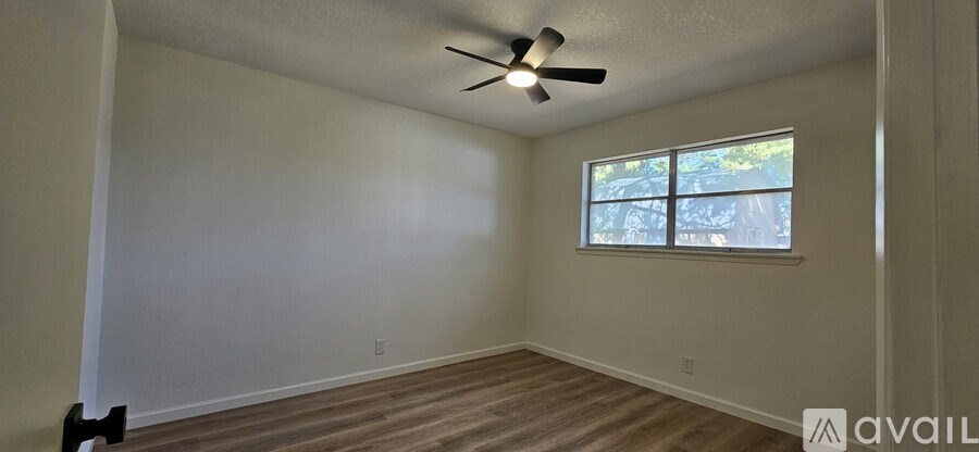 A room with a ceiling fan and a window.