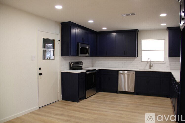 A kitchen with dark blue cabinets and a white countertop.