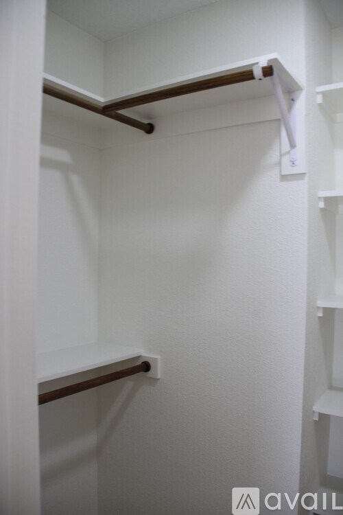 A white closet with a shelf and a hanging rod.