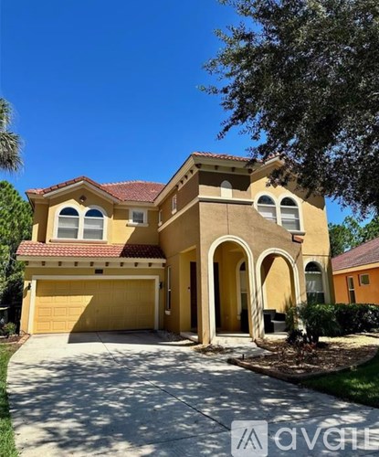 A two-story house with a garage and a driveway.
