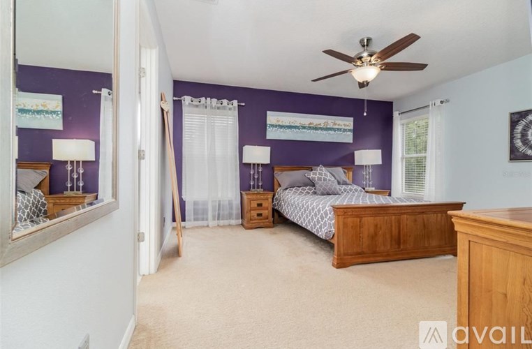A bedroom with a bed, dresser, and mirror.
