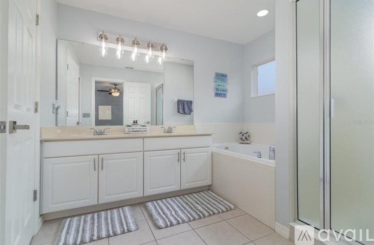 A bathroom with a white cabinet and a glass shower door.