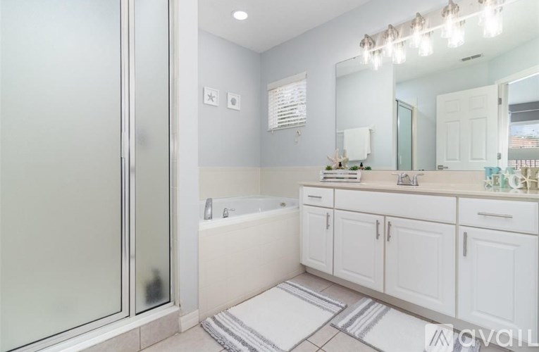 A bathroom with a white tub and a glass shower door.