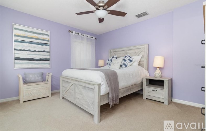 A bedroom with a bed, nightstand, and chair.