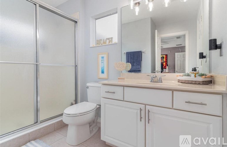 A white bathroom with a toilet, sink, and mirror.