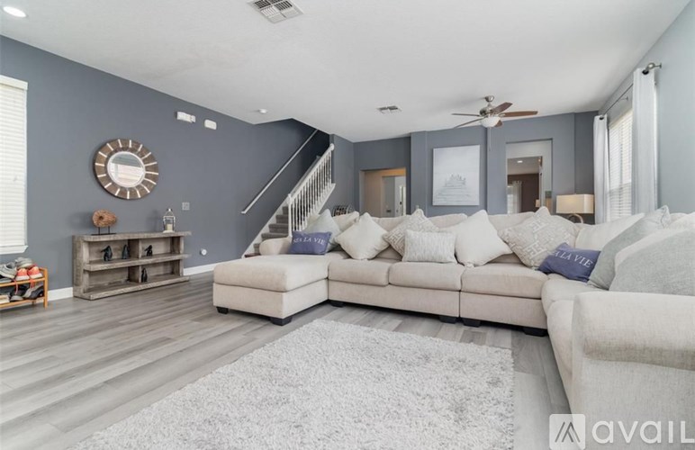 A living room with a white couch and a wooden floor.