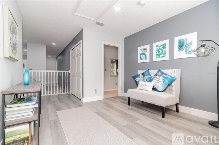 A living room with a white sofa and blue cushions.