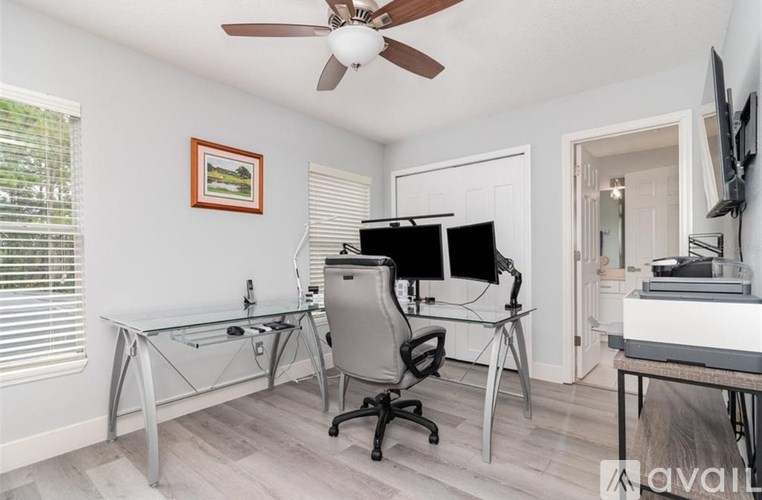 A room with a desk, chair, and computer setup.