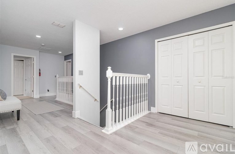 A spacious room with a staircase and a white door.