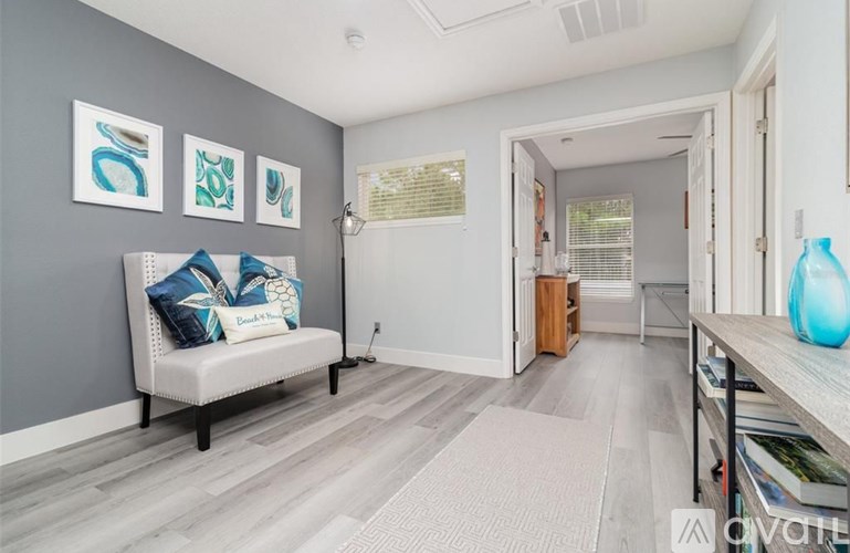 A living room with a white couch and grey walls.